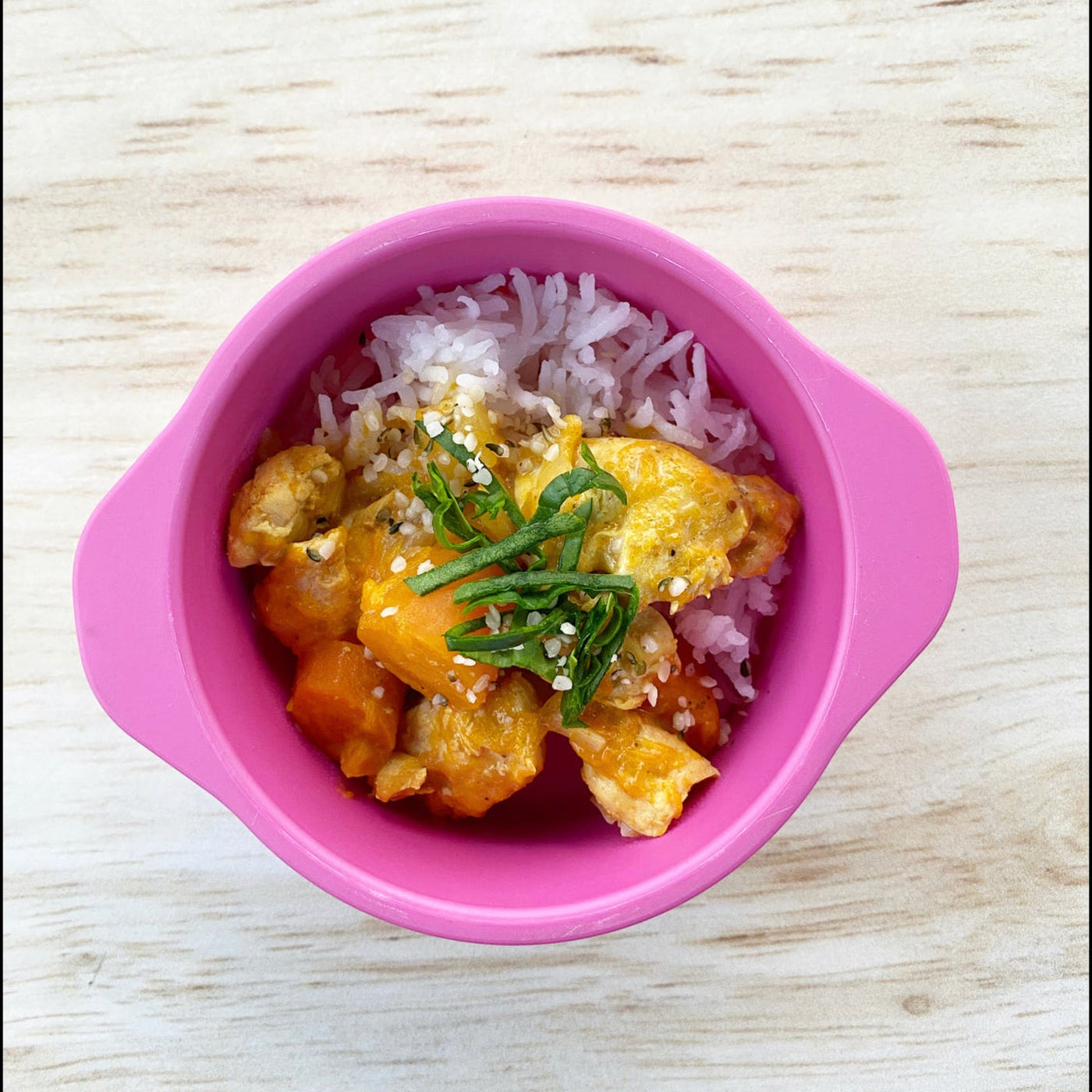 bamboo snack bowl in pink with curry and rice in it 