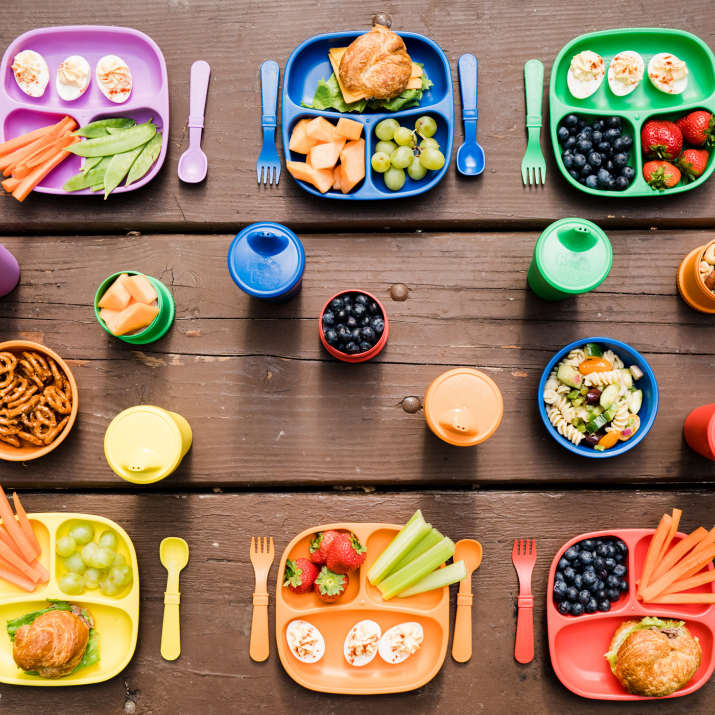 Assorted children's lunch boxes and snacks on a wooden table RePlay Recycled Divided Plate - Bright Pink